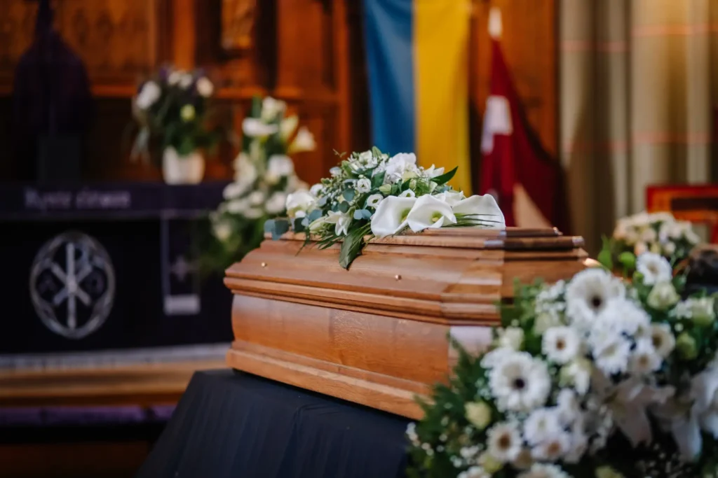 A casket covered with white flowers inside a church